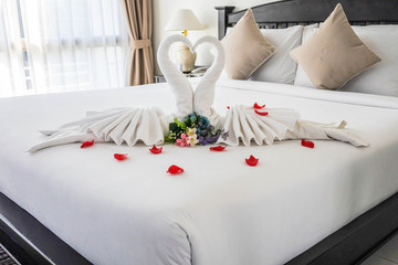 White swan folded towel, Symbols of single-minded love. Set in a white bed for couples in a...