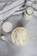  Organic farmer's fresh dairy products: milk, cottage cheese, sour cream. On gray concrete background. Flat lay
