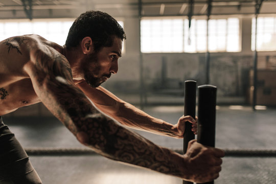 Man performing powerful exercise at cross training gym