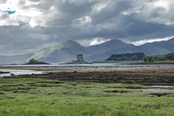 Castle Stalker seen from Jubilee Bridge in Appin with breathtaking view of mountains in the background
