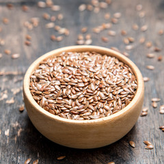 close up of flax seeds on dark wooden background. Healthy food concept for preventing heart diseases and overweight.