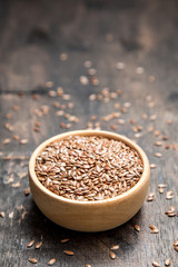 close up of flax seeds on dark wooden background. Healthy food concept for preventing heart diseases and overweight.