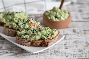 toast with guacamole, seeds and herbs. A cup of coffee. Healyhy Breakfast concept