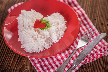 cooked riced in a shape of heart on a red plate 