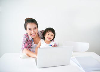 Asian mother woman with a her daughter working at the computer