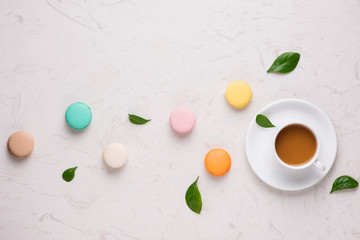 Obraz na płótnie Canvas Tea time flat lay. Cup of coffee and colorful macaroons on the white background