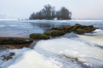 Morning view of Obolon district in Kyiv, Ukraine. A dangerous hobby - winter fishing.  Dnipro River was covered with first thin ice but the lovers of winter fishing are already fishing on the ice