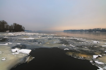 Winter morning view to the Dnipro River in winter. After a cold snap came a thaw. Ice on the river quickly melts and already water is clearly visible. Kyiv, Ukraine