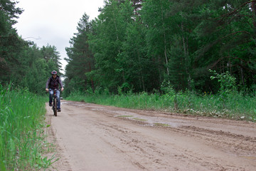 Obraz premium The man on a bicycle. Tourist base in the forest.