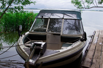 The boat is parked to the river bank. Tourist base in the forest.