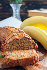 Sliced banana cake with whole-grain flour on a wooden board, selective focus