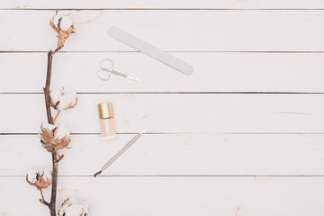 top view of scissors, nail file and nail polish on wooden table