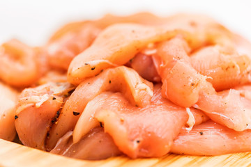 Raw chicken fillet with spices on wooden board