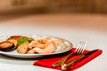 Pieces of roasted chicken and vegetables on plate