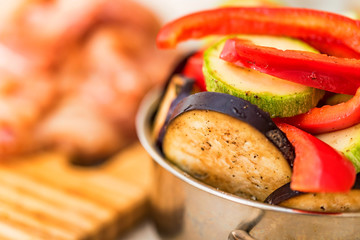 Fresh sliced vegetables in metal pan and meat