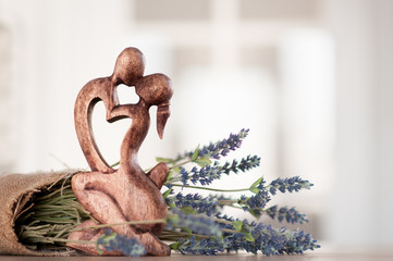 figurine in the form of two men kissing a man and a woman against a background of flowers