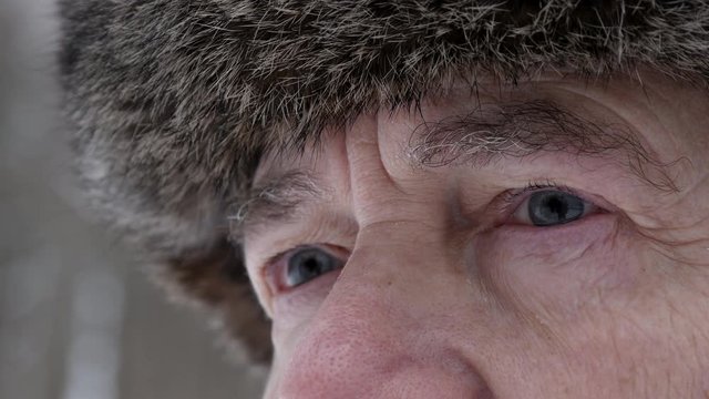 The Eyes Of An Elderly Man In A Fur Hat In Winter Day