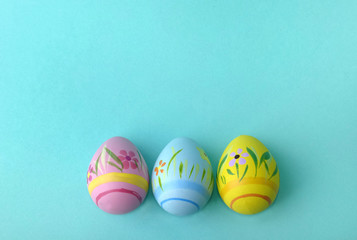 three decorative easter eggs on blue background