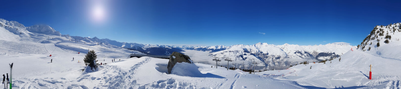 beautiful panoramic landscape on the slopes in  the snowy mountain under sunny blue sky