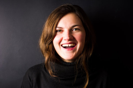 Happy brunette smiling portrait on dark background