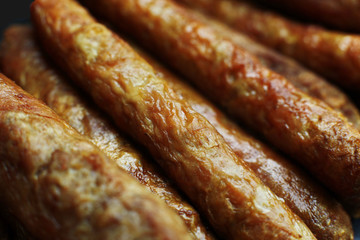 Barbecued meat sausages (bratwurst) close up. Grilled delicious sausages macro shoot.