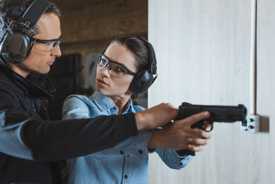 male instructor helping customer in shooting range
