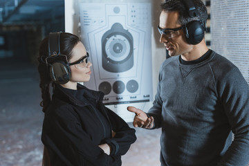 shooting instructor and client talking in shooting range © LIGHTFIELD STUDIOS