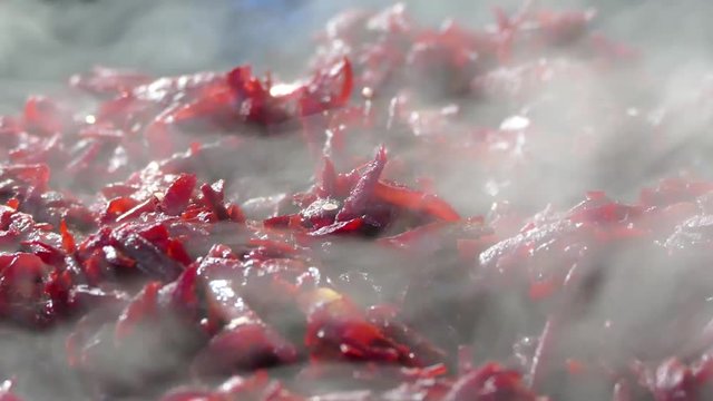 Red beets are stewed in a frying pan. There is steam from a hot dish.