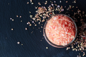 Pink Himalayan salt in jar on dark slate background. Top view. - obrazy, fototapety, plakaty