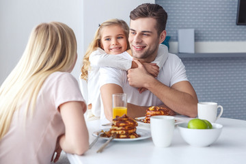 happy family having breakfast and playing on weekend morning