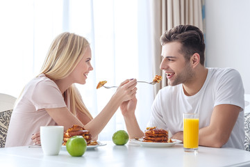 Obraz na płótnie Canvas young couple feeding each other with breakfast