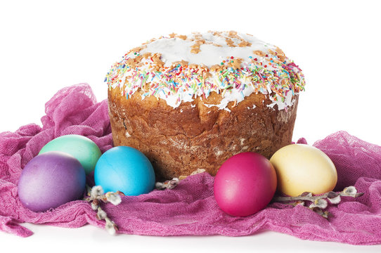 Scattered painted easter chicken eggs, traditional orthodox christian easter food kulich with raisins and branches of willow