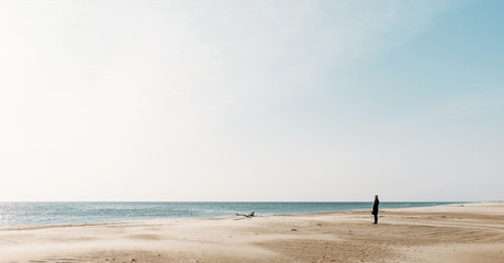 Fototapeta na wymiar Woman walking on sandy coast.