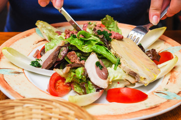 visitor eats salad with Norman meat appetizers