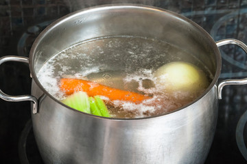 boiling meat broth in steel stockpot
