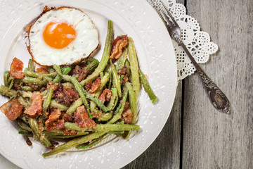 Healthy sauteed green beans with bacon and fried egg