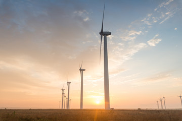 Fototapeta na wymiar Wind turbines against red, blue and orange sunrise