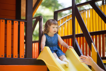 Little kid on playground, children's slide.