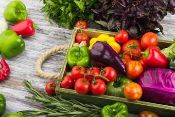 Colored vegetables in the wooden tray, light wooden background