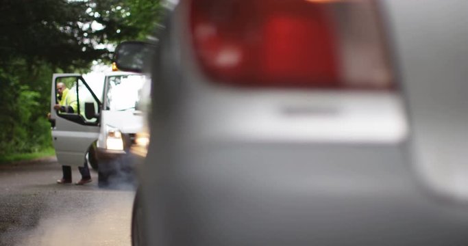 4K Recovery driver arrives at scene of breakdown to help stranded motorist get back on the road. Slow motion.