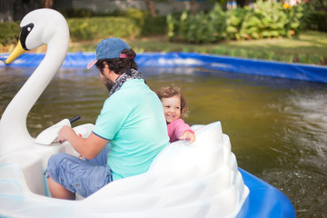 Little girl and her father at amusement park.