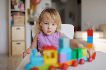 the little girl plays in the house multi-colored blocks