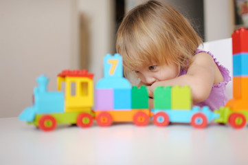 the little girl plays in the house multi-colored blocks