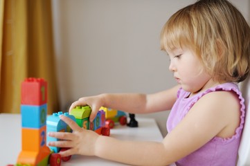the little girl plays at home in developing games