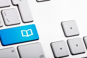 Blue Bottom on a Laptop with Open Book - Close Up