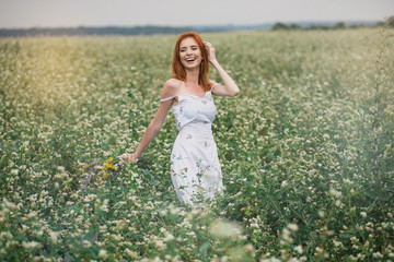 young beautiful girl in the field with flowers