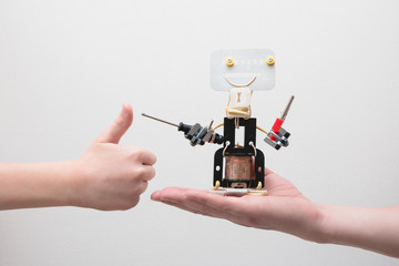 STEM education. Metal robot made by hands in a class in chemistry and robotics on the hand of...