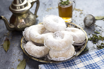 Oriental Algerian sweet cookies( kaab el ghazal), tea cup and pot  and mint leaves