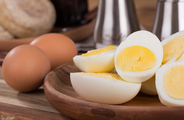 Closeup of sliced hard boiled eggs on a wooden plate