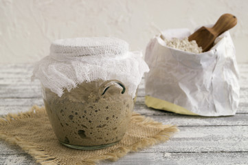 Fototapeta na wymiar Active rye sourdough in a glass jar for homemade bread.